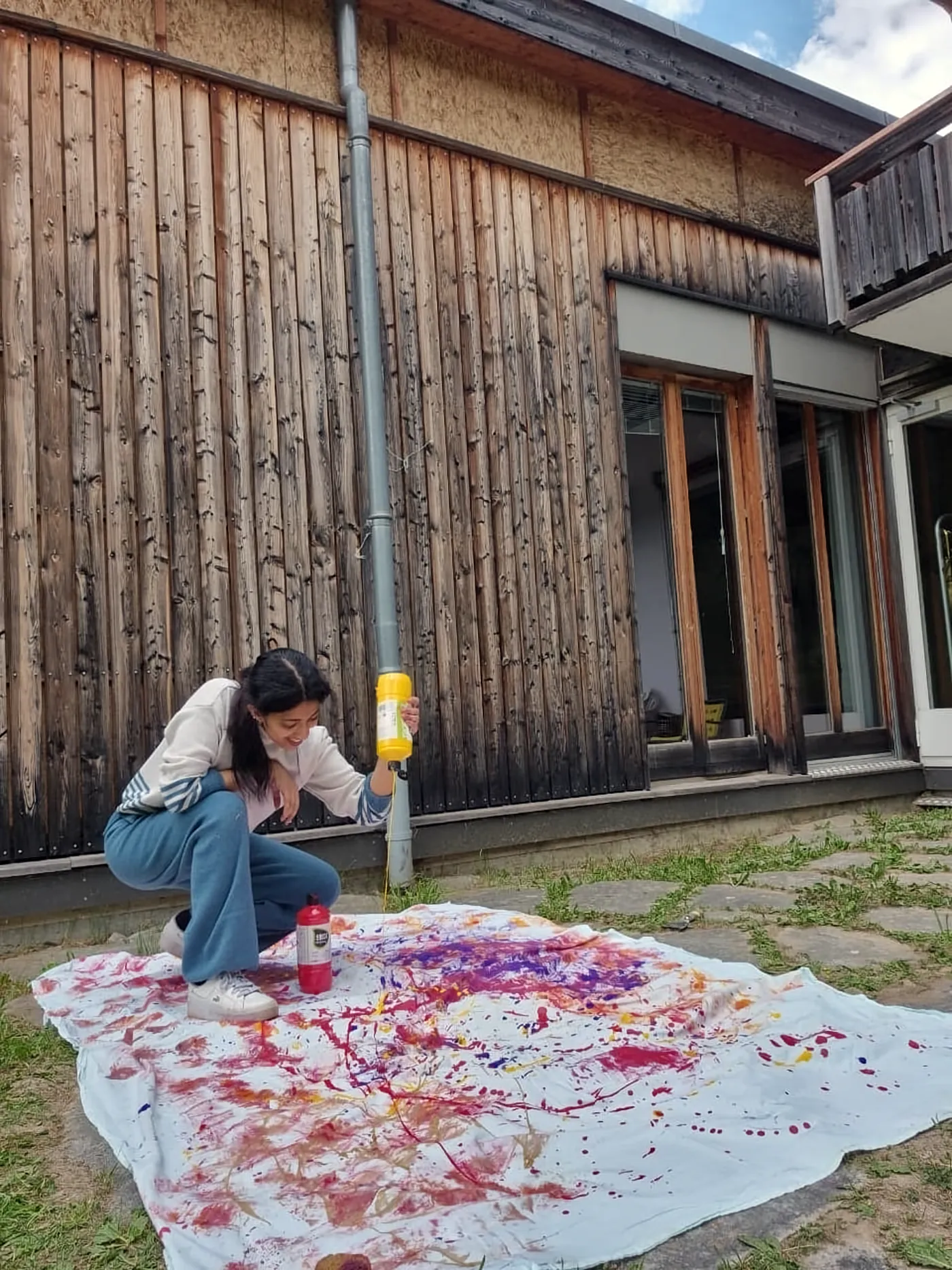Ritty adding colour to a large painting on cloth