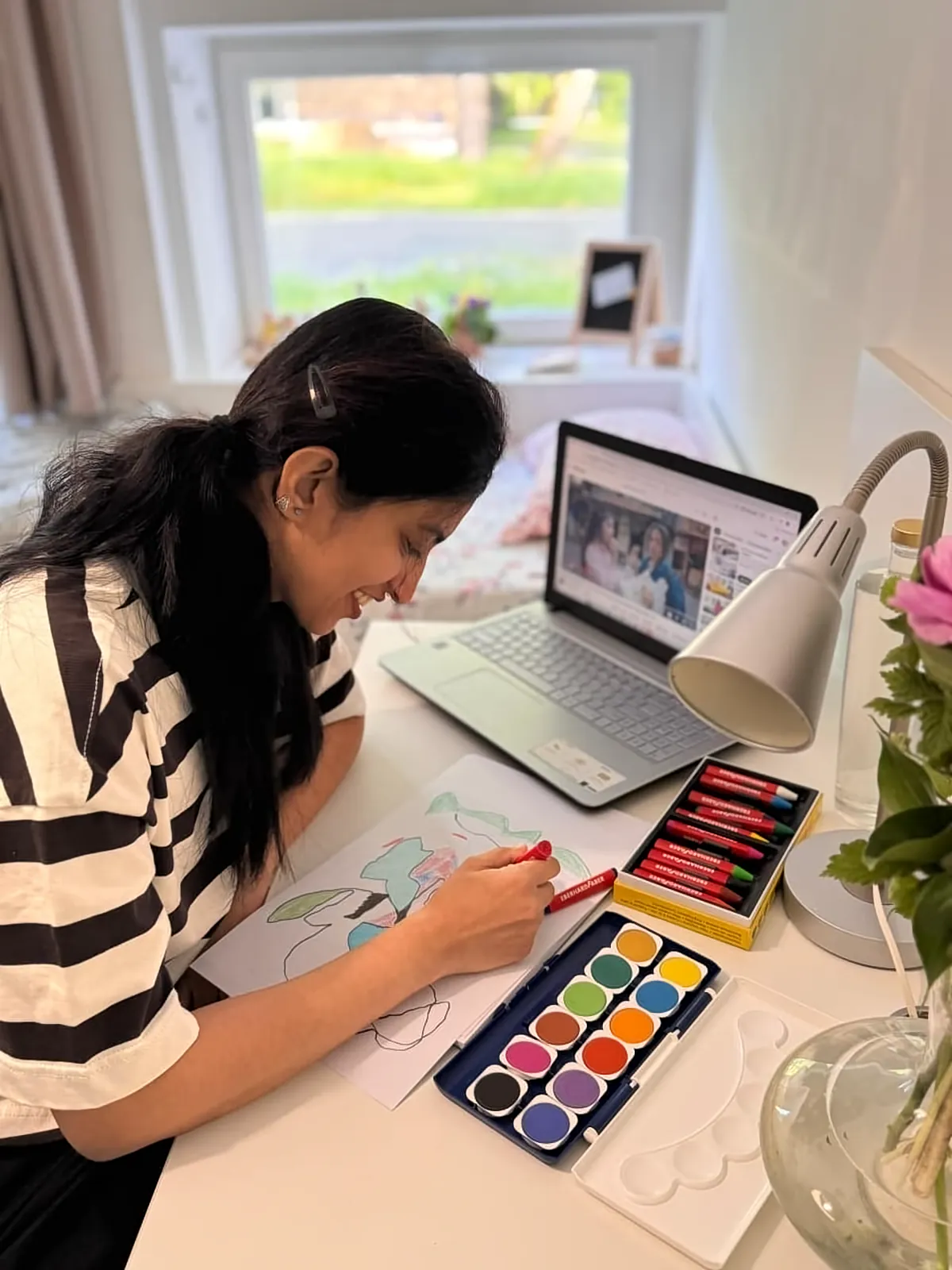 Ritty drawing with oil pastels at her desk