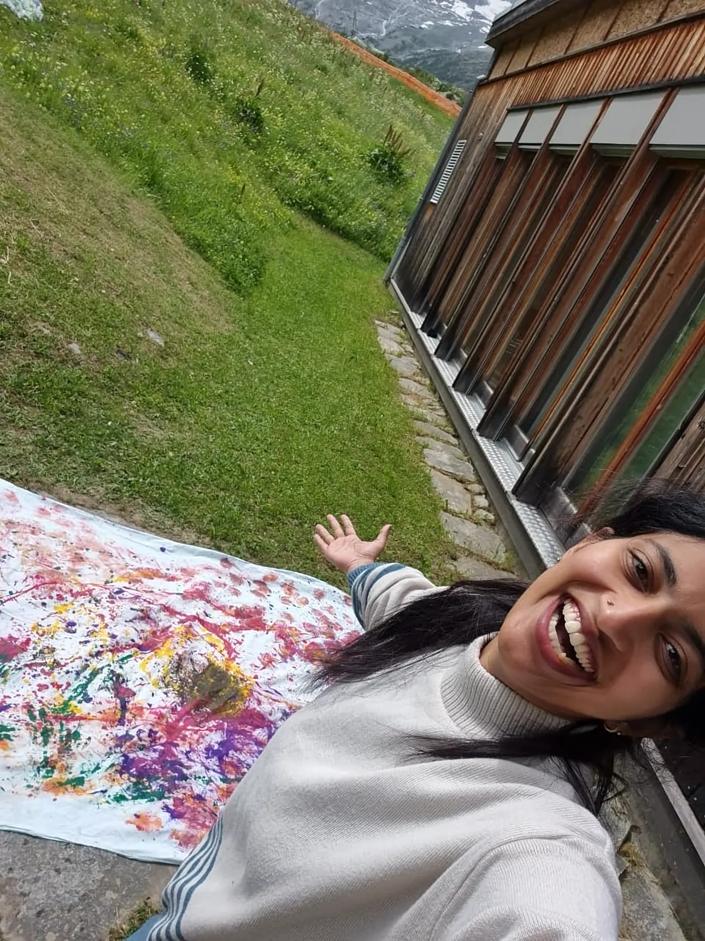 Ritty laughing next to a large colourful painting